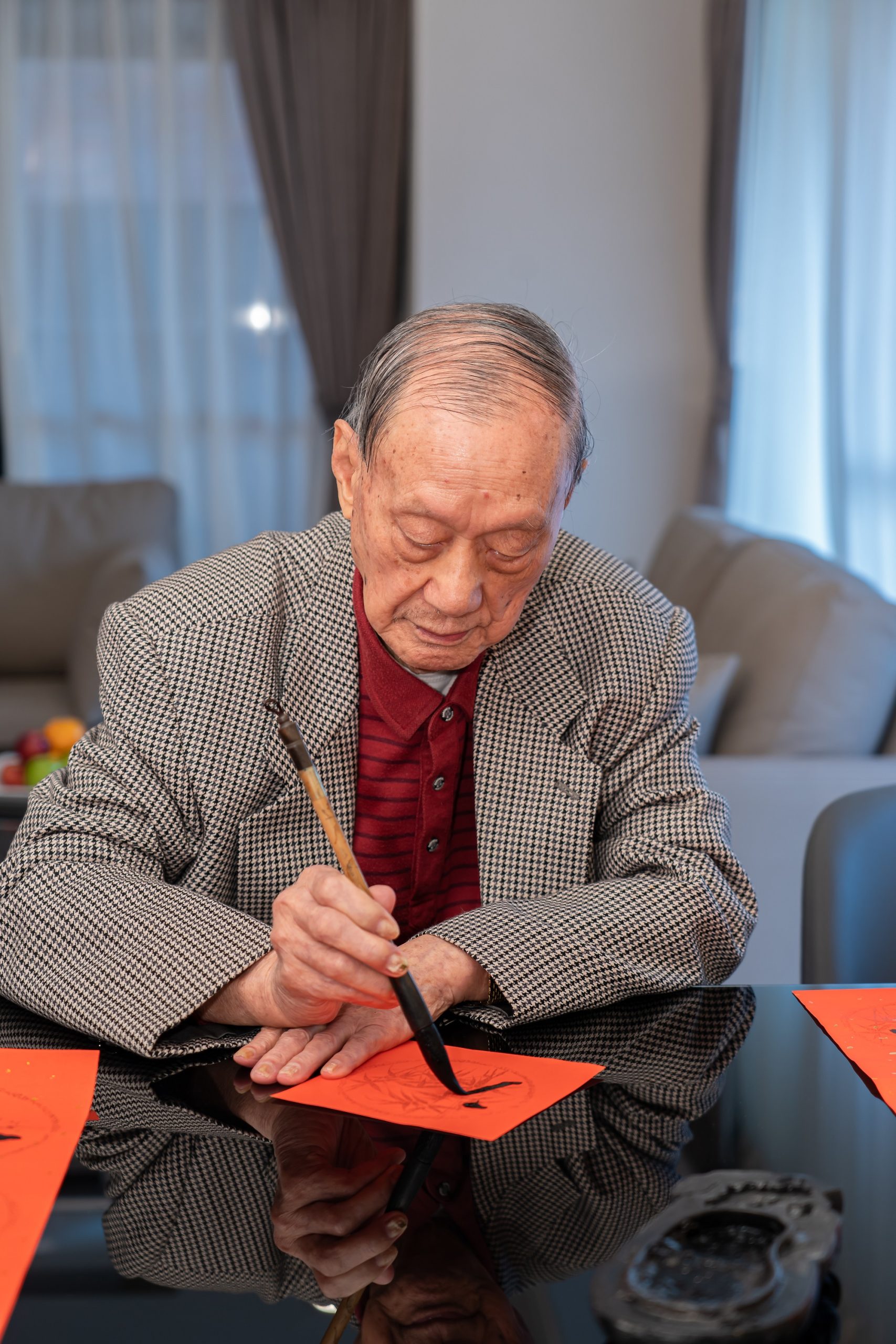 100歲的吳珍富爺爺正為採訪團隊揮毫（攝影／劉字軒）